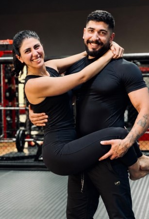 Arash carrying Sadaf in the gym, both smiling